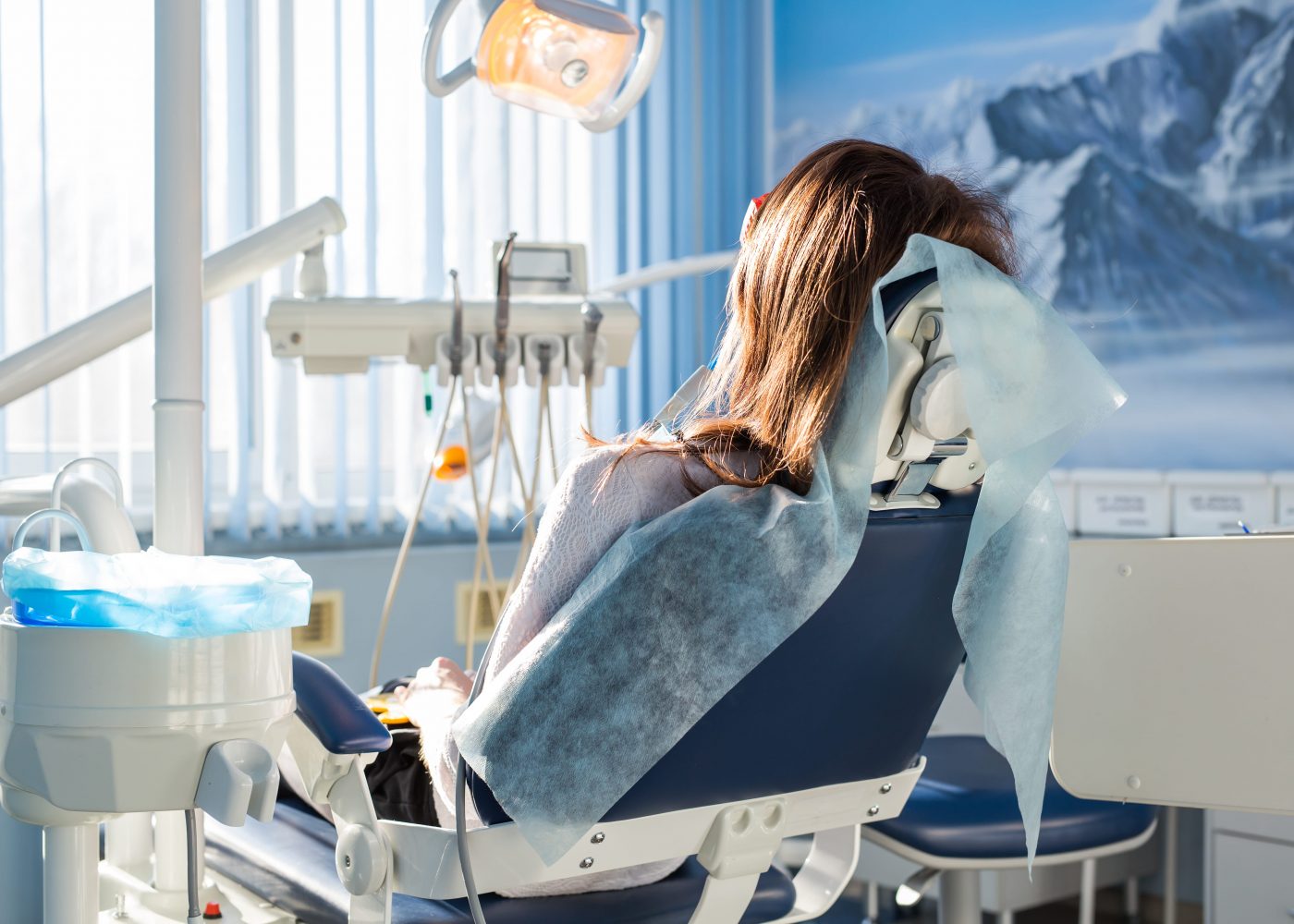 Patient sitting on dental chair, waiting for her dentist. Dental medicine, dental care, prevention, health concept.